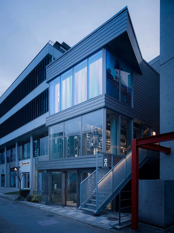 Outside view of an On Running store with large glass windows.
